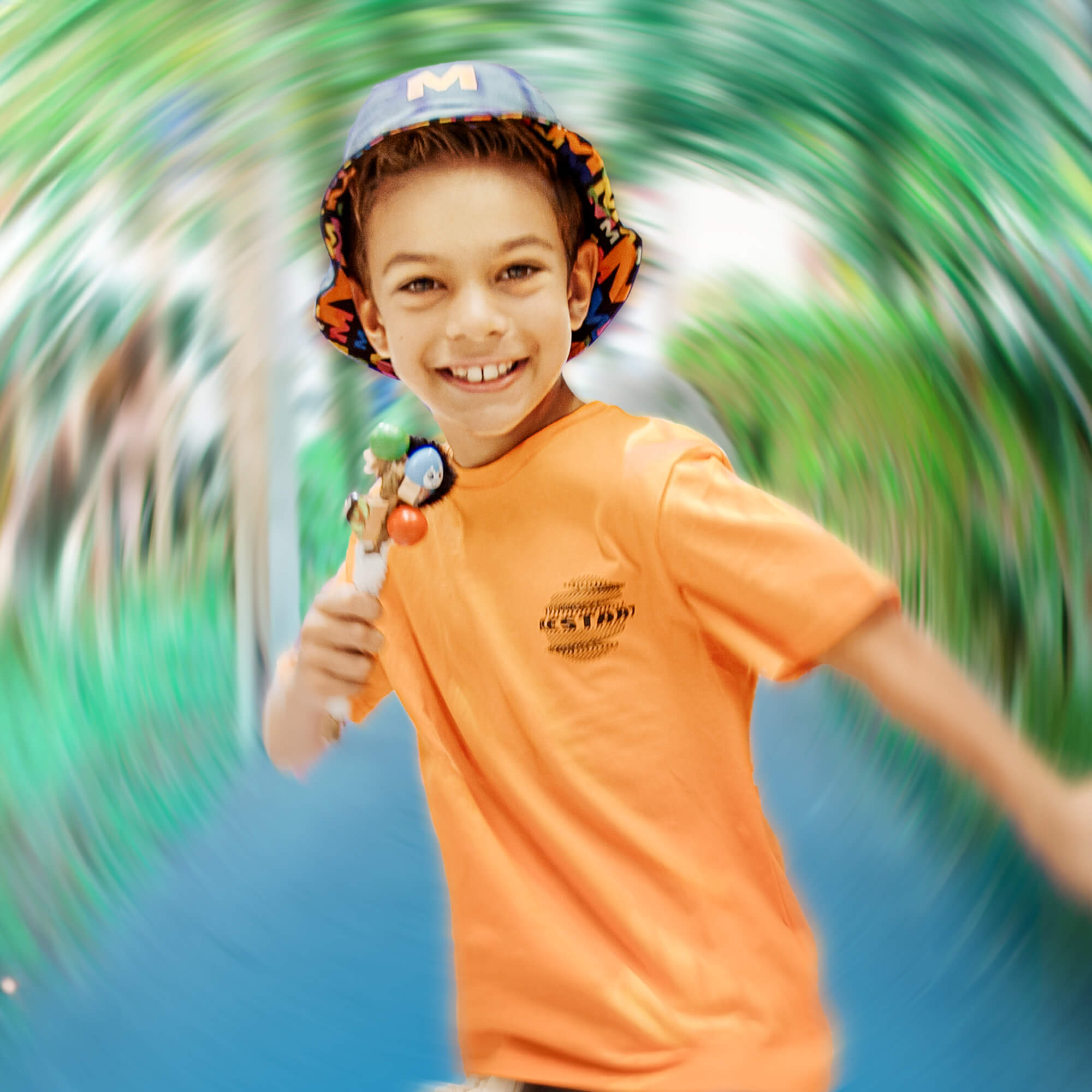 Child holding a toy and wearing a hat