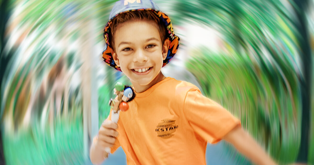 Child holding a toy and wearing a hat